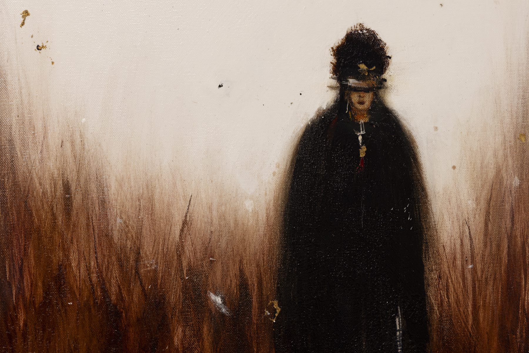 Dark solitary figure emerging from a warm textured landscape.
