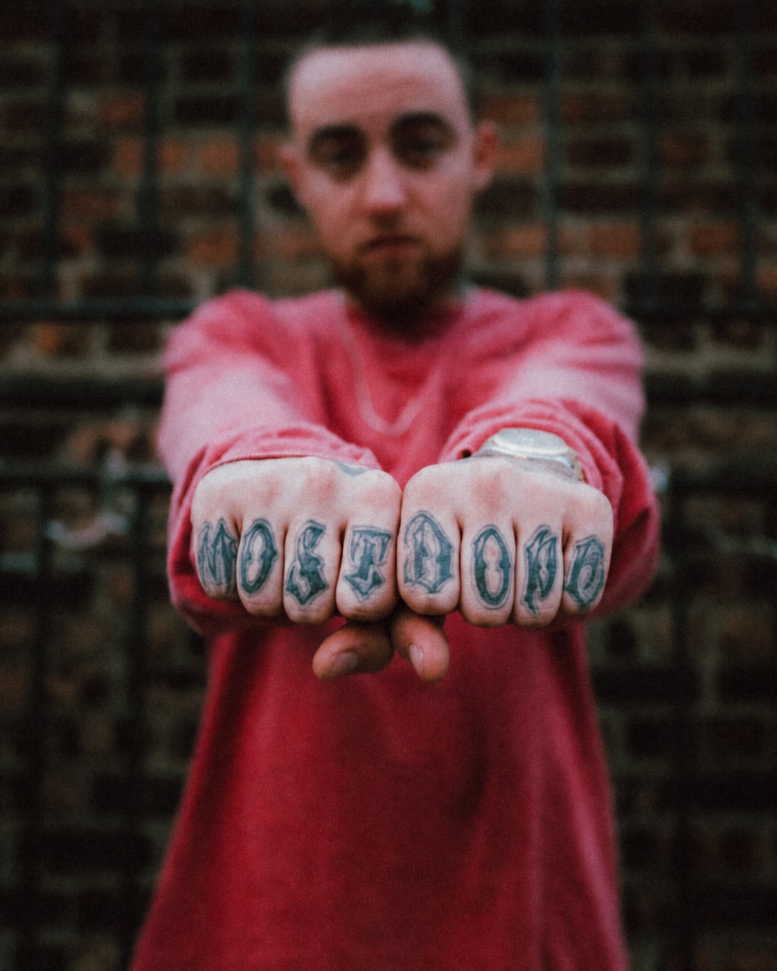 Brian Alcazar extending his tattooed fists toward the camera.