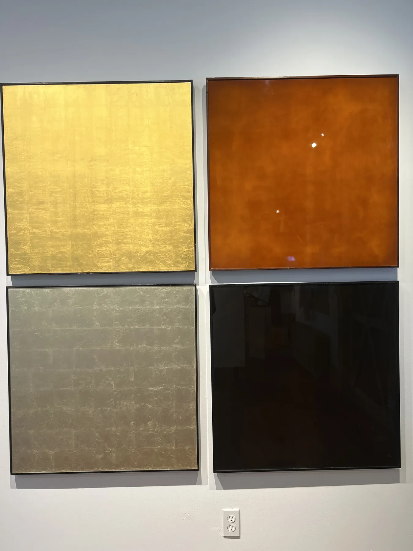 The Grid, a four-panel artwork in gold, rust, silver, and black by Nicholas Mongiardo.