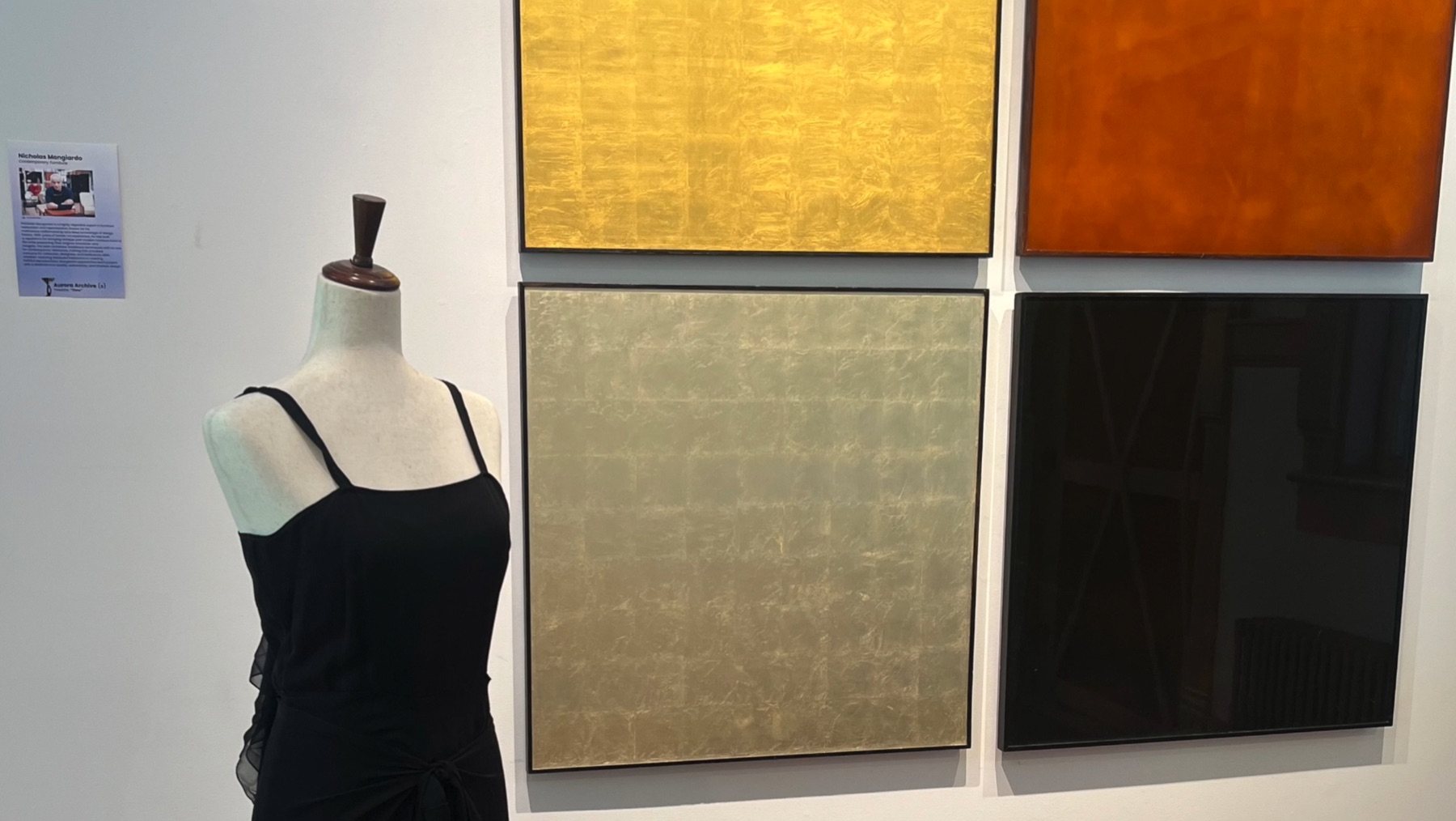 Gallery wall with framed artworks in gold, red, neutral, and black tones.
