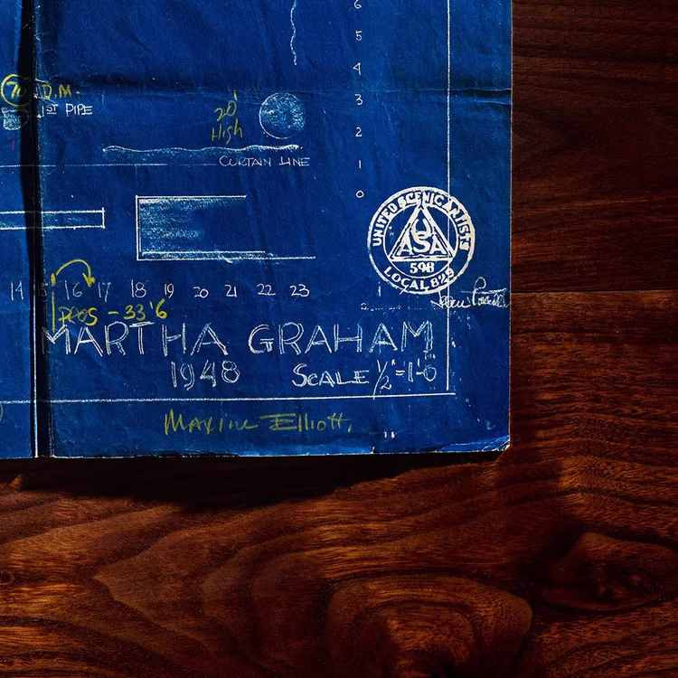 Photograph of a Martha Graham stage plan resting on a wood surface.