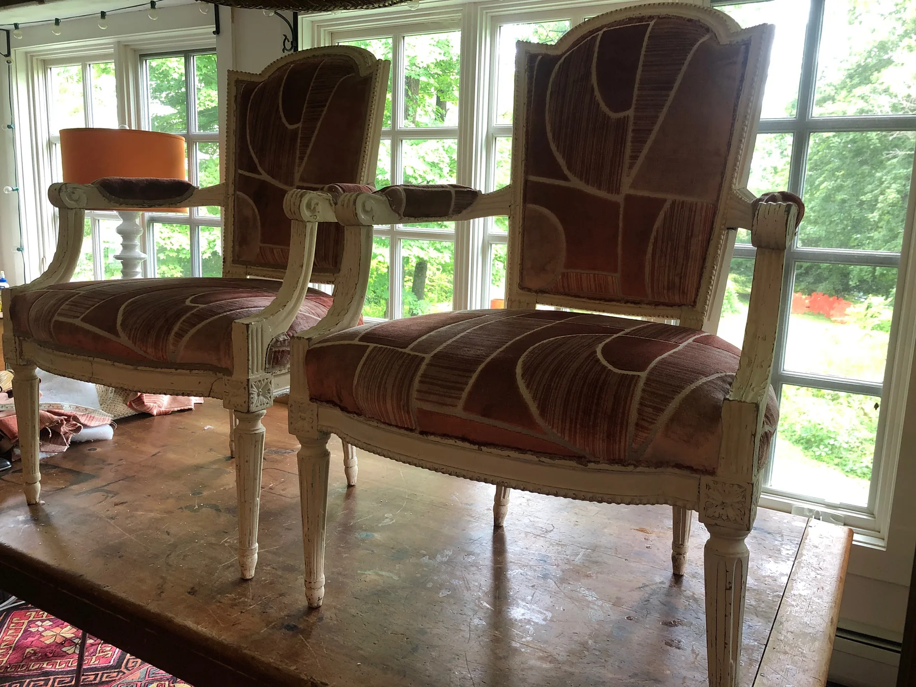 Pair of antique chairs reupholstered in a rose and cream geometric textile.