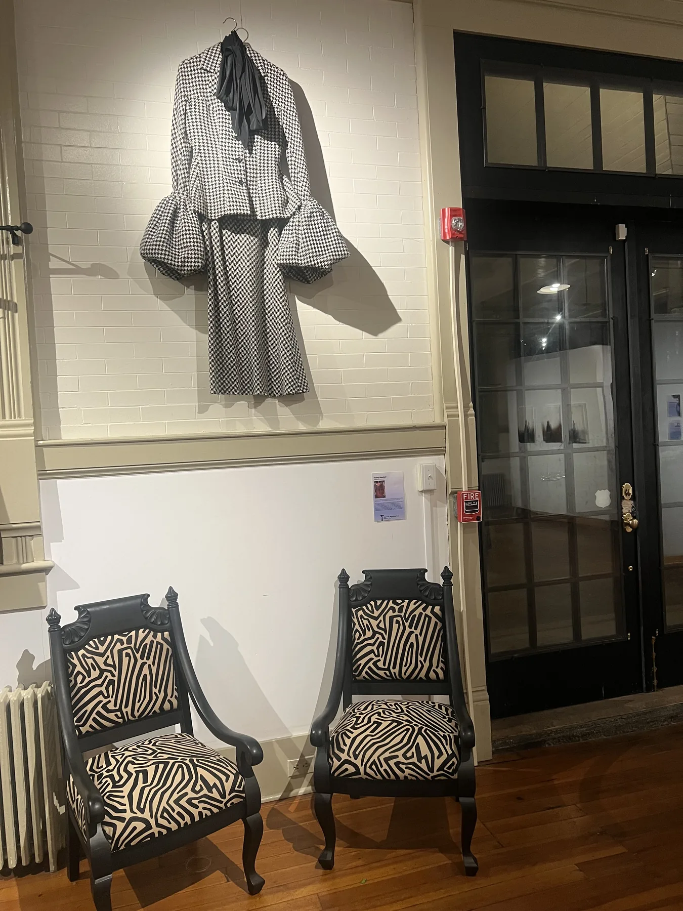 Yohji Yamamoto herringbone and silk bow shirt installed above two chairs.