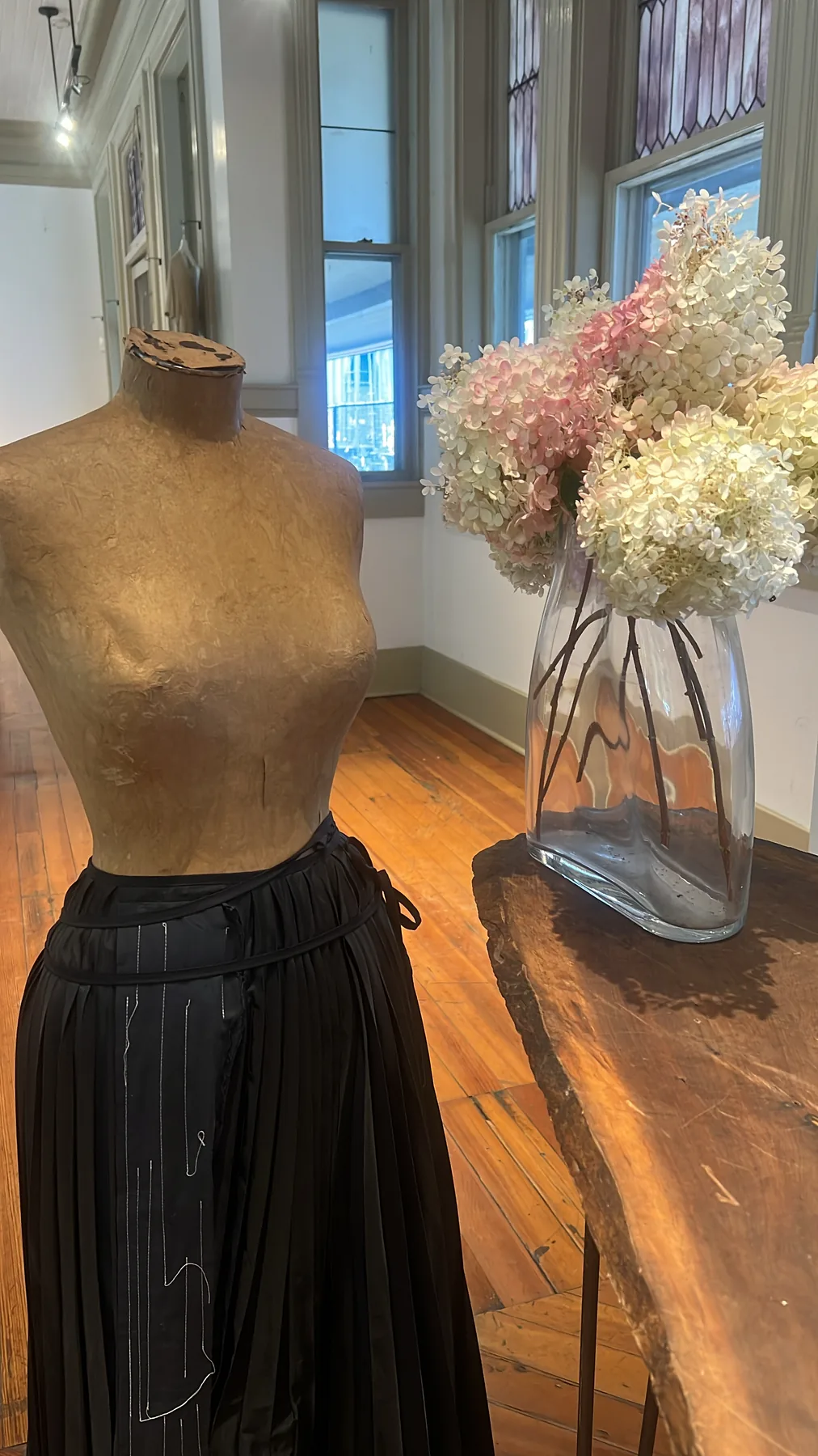 Close view of a black Yohji Yamamoto skirt on a dress form.